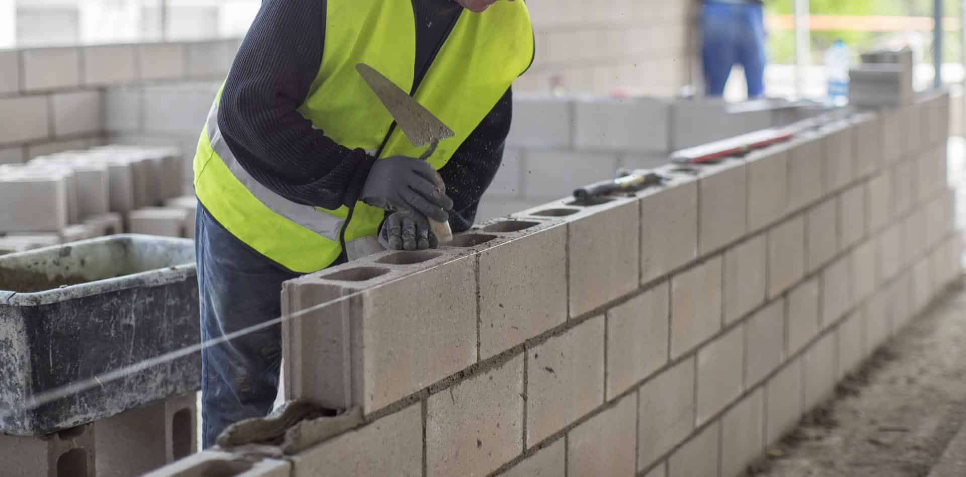 Workers On A Construction Site. Masonry Walls.
